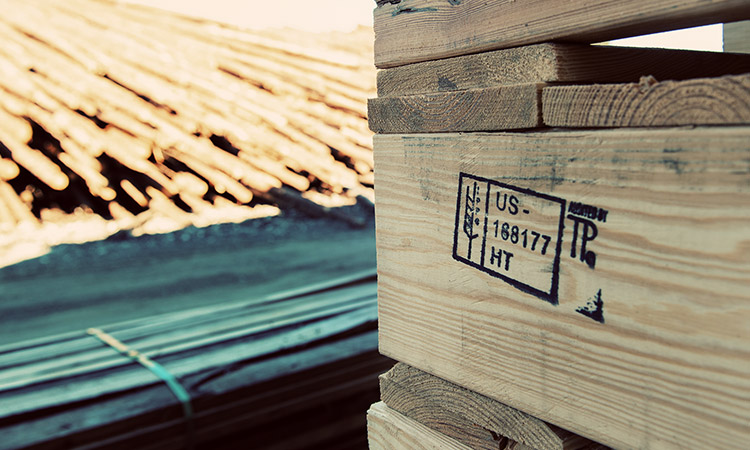 Stacked pallets with timber in the background